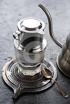 Vietnamese coffee with milk in a glass on metal tray