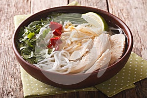 Vietnamese cuisine: soup Pho Ga with chicken, rice noodles and f photo