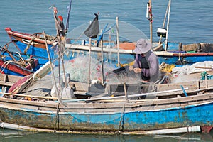 Vietnamese fisher untangles nets