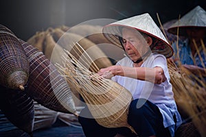 Vietnamese fishermen are doing basketry for fishing equipment at photo