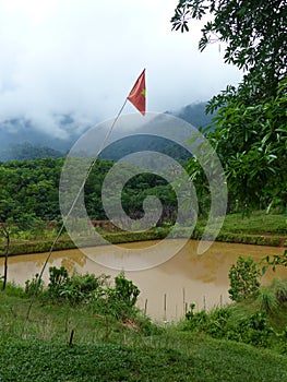 Vietnamese flag near a water reservoir in the mountain of North Vietnam.