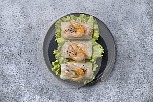 Vietnamese food spring rolls with shrimps in rice paper on grey. View from above. Asian cuisine