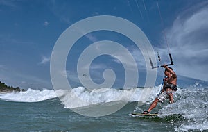 Vietnamese kite surfer jumps with kiteboard photo