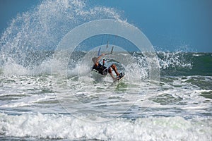 Vietnamese kite surfer jumps with kiteboard photo