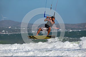 Vietnamese kite surfer jumps with kiteboard photo