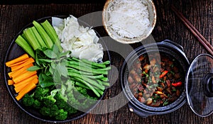 Vietnamese meal for vegetarian, plate of boiled vegetables, vegan braised sauce in pot with rice