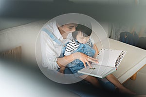 Vietnamese mother and little daughter girl reading a book in the