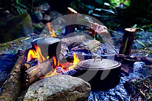 Vietnamese pots cooking over open flame, cooking on campfire.