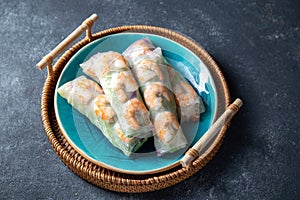 Vietnamese spring rolls with shrimps on blue plate.