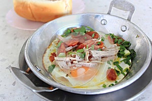 Vietnamese style fried egg in pan with white pork sausage