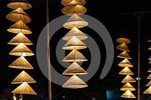 Vietnamese traditional conical hats hanging on wire for decoration.