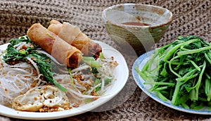 Vietnamese vegetarian food for breakfast, rice noodle with fried spring roll, vegetables for vegan meal