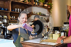 Vietnamese waitress serving ice cream for a customer in a coffee shop