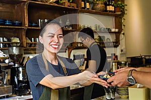 Vietnamese waitress serving ice cream for a customer in a coffee shop