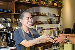 Vietnamese waitress serving ice cream for a customer in a coffee shop