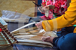 Vietnamese woman craftsman making the traditional vietnam hat in the old traditional house in Vietnam. Traditional artist concept