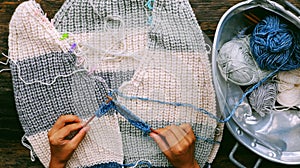 Vietnamese woman hands knitting woollen sweater, knit at home to make handicraft clothing