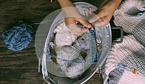 Vietnamese woman hands knitting woollen sweater, knit at home to make handicraft clothing