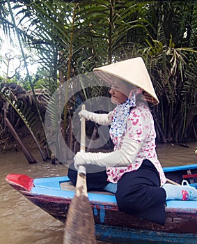 Vietnamese woman paddling at Mekon Delta