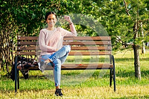 Vietnamese woman in pink sweater sitting on the bench photo