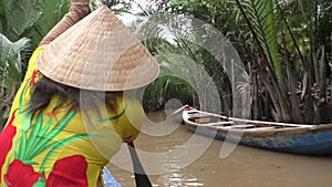 Vietnamese woman rows a boat, Mekong River