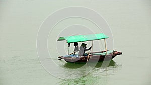 vietnamese woman with traditional dress paddling boat,halong bay,vietnam