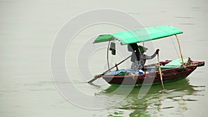 vietnamese woman with traditional dress paddling boat,halong bay,vietnam