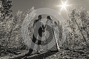 Vietnamese woman in a traditional wedding dress with her husband in the fall leaves of the Colorado Rocky Mountains