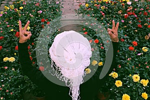 Vietnamese woman with white hair sit among roses garden