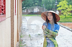 Vietnamese women wear Ao dai in the rain