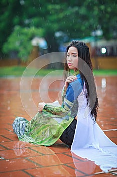 Vietnamese women wear Ao dai in the rain photo
