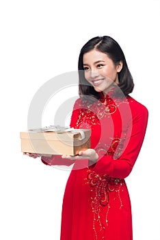 Vietnamese young woman in Ao Dai dress holding gift box.