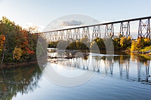 View of a 1908 railway trestle bridge and its reflection in the Cap-Rouge River