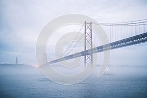 View of 25 de Abril Bridge famous tourist landmark of Lisbon in heavy fog mist