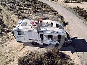 Married couple sitting on the roof of camper photo