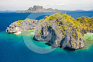 View from above, aerial view of unknown Island surrounded by turquoise, crystal clear sea. Bacuit Bay, El Nido, Palawan,
