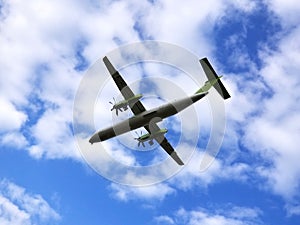 View from above on airplane in flight. Aircraft is flying in blue cloudy sky