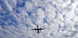 View from above on airplane in flight. Aircraft is flying in blue cloudy sky. Original sound.