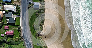 A view from above of arriving waves on the beach and roofs of houses. Shevelev.