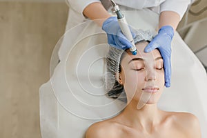 View from above of beautiful woman enjoying cosmetology procedures, rejuvenation in beauty salon. Dermatology, doctor at