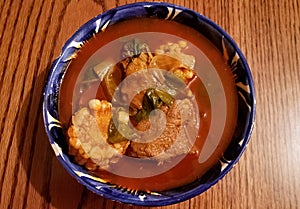 View from above of a blue ceramic plate with mole de olla, typical Mexican soup