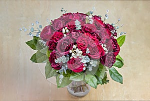 View on above on a bouquet of red roses with green leaves in a g