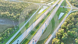 View from above of busy American highway bridge with fast moving traffic in green Florida area in the evening