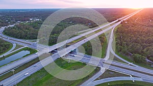 View from above of busy american highway crossroads with fast moving traffic in green Florida area in the evening
