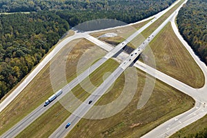 View from above of busy american highway with fast moving traffic between woods. Interstate transportation concept