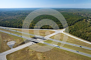 View from above of busy american highway with fast moving traffic between woods. Interstate transportation concept