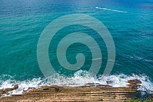 View from above, of the cliff of the flysch of Zumaia, with the blue sea with waves,