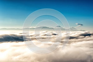 View above the clouds with in the distance the popocatepetl volcano, Mexico photo