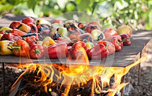 View from above of colorful red, green and yellow stuffed veggy savory bell peppers grilling on a BBQ