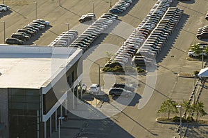 View from above of dealers outdoor parking lot with many brand new cars in stock for sale. Concept of development of
